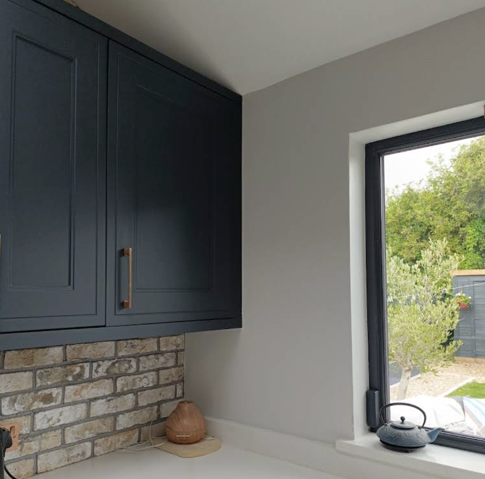 Dark kitchen units with brick splashback
